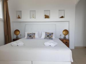米克诺斯城贝卢套房公寓的卧室配有白色床和毛巾
