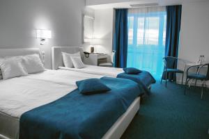 康斯坦察Continental Forum Constanta的酒店客房带两张床和一张桌子以及椅子。