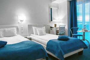 康斯坦察Continental Forum Constanta的酒店客房设有两张床和一张桌子。