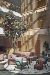 特洛普拉赫福肯斯坦卡琳兹亚酒店 的大堂配有沙发、椅子和树木