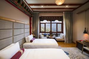 KaghaWilling Resort, Trongsa的酒店客房设有两张床和窗户。