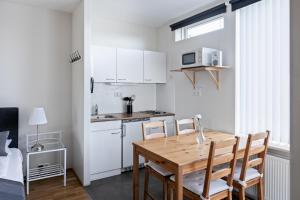 BrautarholtSouth Central Apartments的一个带木桌和椅子的小厨房