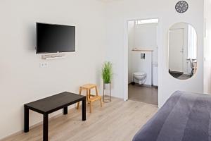 BrautarholtSouth Central Apartments的客厅设有床铺和墙上的电视