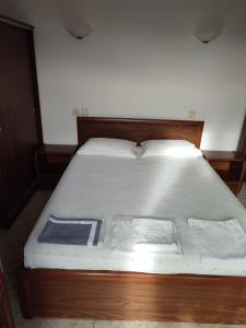 欧拉努波利斯Ξενώνας Φωτεινη的一张带木制框架和白色床单的床