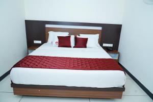 蒙纳Rainbow Inn的一间卧室配有一张带红色枕头的大床