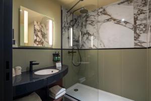 克利希voco Paris - Porte de Clichy, an IHG Hotel的一间带水槽和淋浴的浴室