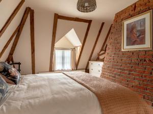 Bentley2 Bed in Tattingstone 86982的一间卧室设有砖墙和一张床