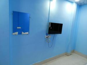 乌贾因M Baba Guest House的一间设有蓝色墙壁和电视的客房
