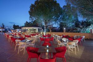 贝莱克Aydinbey Queen’s Palace & SPA的一间带桌子和红色椅子的餐厅