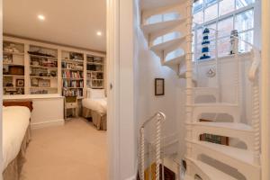 伦敦Character Cottage In Historic Hampstead的卧室内的白色楼梯