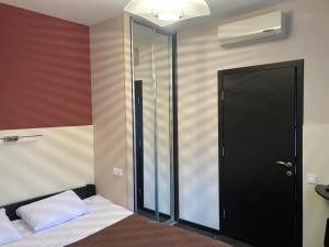 哈尔科夫Міні-готель Тремпель的一间卧室设有一张床和一个黑色的门