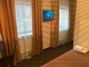 哈尔科夫Міні-готель Тремпель的酒店客房的墙壁和窗帘上配有电视