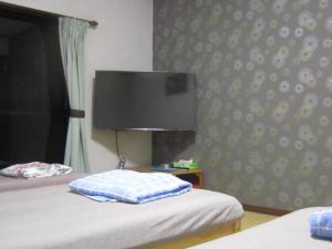 沼津Minato Oasis Numazu - Vacation STAY 31031v的一间卧室配有两张床和一台平面电视