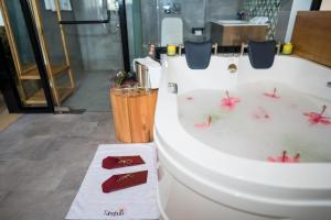 波特尔堡Tabebuia Spa and Safari Resort的浴室设有粉红色花卉浴缸。