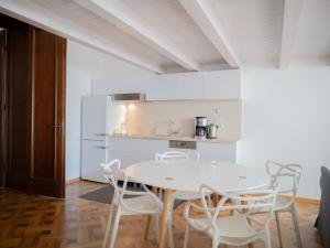 布拉索夫卡萨曼德尔公寓的白色的厨房配有白色的桌子和椅子