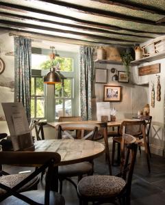 安布尔塞德Wateredge Inn- The Inn Collection Group的一间带桌椅的用餐室和窗户。