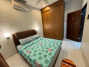 大山脚Cozy House 37 @ Alma BM的一间卧室配有一张带绿色棉被的床