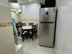 大山脚Cozy House 37 @ Alma BM的厨房配有冰箱和桌椅