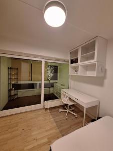 GreveApartment Hundige的白色的客房设有书桌和窗户。
