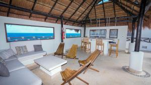 女人岛Casa Javi- Ocean Front located Mid Isla Mujeres的客厅配有沙发、椅子和桌子