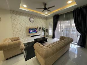 De’ Nuhir Homestay Teluk Senangin的客厅配有两张沙发和一台电视机