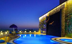 麦纳麦巴林泽夫瑞雅酒店的一座游泳池,在晚上在一座建筑的顶部