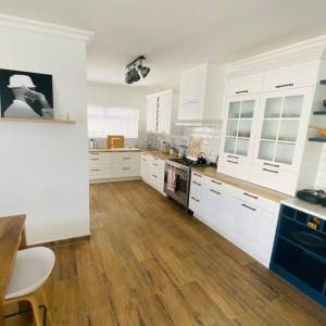斯瓦科普蒙德3 BDR Villa , unique in Swakopmund的厨房铺有木地板,配有白色橱柜。