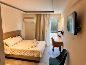 拉纳卡圣雷莫酒店 的一间卧室配有一张床、一张书桌和一台电视
