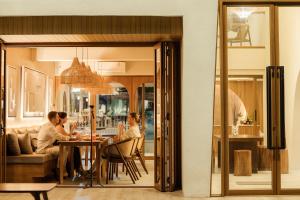 格兰岛Tasana bar and luxury resort的一群人坐在一个房间里桌子上