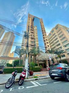 圣保罗LFlats no Hotel Stella Vega (EX-Mercury Ibirapuera)的停在大楼前停车场的摩托车