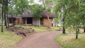 法尔瓦特Ilanga Safari Lodge - Welgevonden Game Reserve的树屋前的砖路