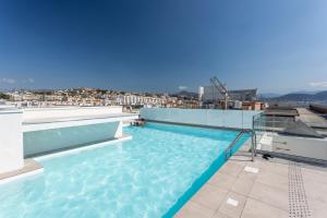 尼斯Nemea Appart Hotel Nice Arenas Aéroport的建筑物屋顶上的游泳池