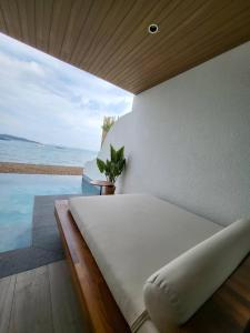 格兰岛Tasana bar and luxury resort的一间卧室配有一张床,享有海景