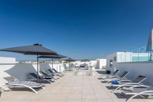 尼斯Nemea Appart Hotel Nice Arenas Aéroport的屋顶上一排椅子和遮阳伞