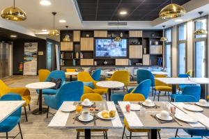 尼斯Nemea Appart Hotel Nice Arenas Aéroport的一间带桌椅和电视的用餐室