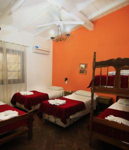 比亚莱特马西Complejo Turistico - Hotel Pinar serrano - Bialet Masse - Cordoba的一间卧室配有三张双层床和红色的墙壁