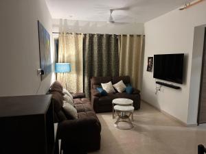 孟买Room in Flat with Amazing City and Sea View的带沙发和电视的客厅