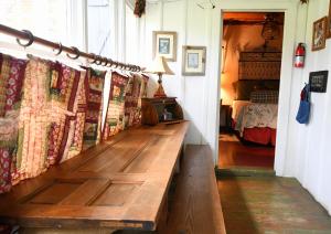 格伦罗斯Country Woods Inn的配有床的客房内的木凳