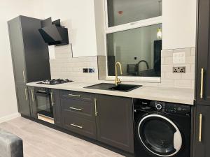 水晶宫Newly Refurbished 1Bedroom 4 mins walk to Crystal Palace Station的厨房配有洗衣机和水槽