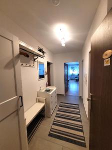 温特贝格Winterberg Appartement 21117的走廊上设有带水槽和镜子的浴室