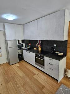 利莫内皮埃蒙特Bella vista的厨房铺有木地板,配有白色橱柜。