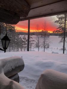 库萨莫Villa Kuiske的享有雪覆盖的庭院和日落美景