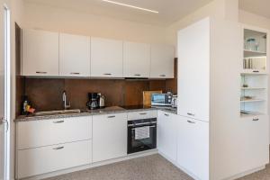 托里德尔贝纳科Casa Serena的白色的厨房配有白色橱柜和电器