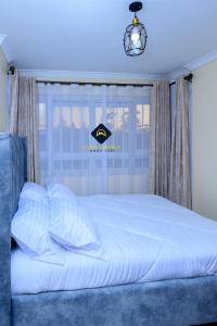 内罗毕Jalde Heights, Limuru Road, 178, Nairobi City, Nairobi, Kenya的卧室配有白色的床和窗户