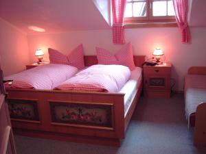 上蒂利拉赫纳芙勒霍夫酒店的一间卧室配有两张单人床和红色枕头