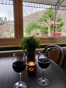 布莱勒Hotel Rêve de la Vallée的桌子上两杯红酒,窗户上