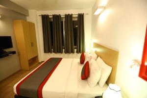 古尔冈BK Studio And Rooms Near Huda City Centre的一间卧室配有带白色床单和红色枕头的床。