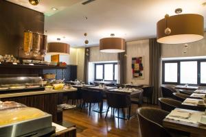 罗马Divina Luxury Hotel的餐厅设有桌椅和窗户。