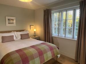 莱姆里吉斯Cobblers Lodge的一间卧室设有一张床和一个大窗户