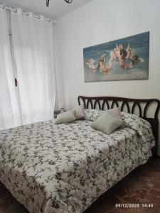 米兰CASA DI LORY的卧室配有一张床,墙上挂有绘画作品